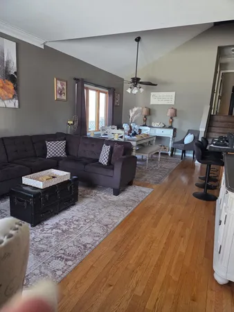 a kitchen with granite countertop a refrigerator a sink dishwasher and wooden cabinets with wooden floor