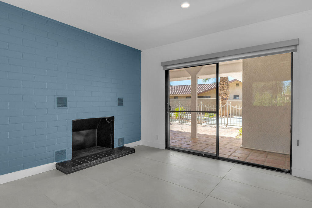 44635 San Carlos Avenue Palm Desert, CA 92260 - Photo 21 of 64 a view of an empty room with a fireplace and a window