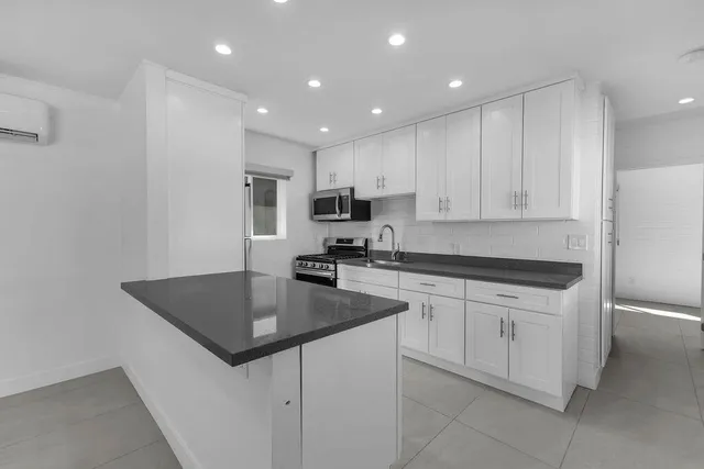 a view of a house with a yard and potted plants