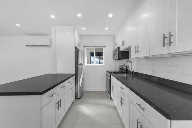 an aerial view of a city with lots of residential buildings ocean and mountain view in back