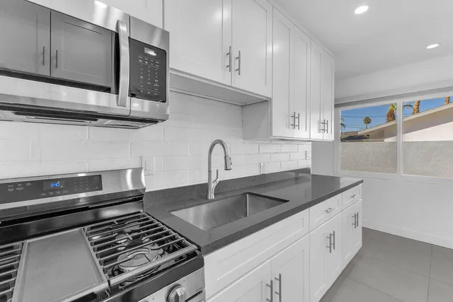 an aerial view of a city with lots of residential buildings and mountain view in back
