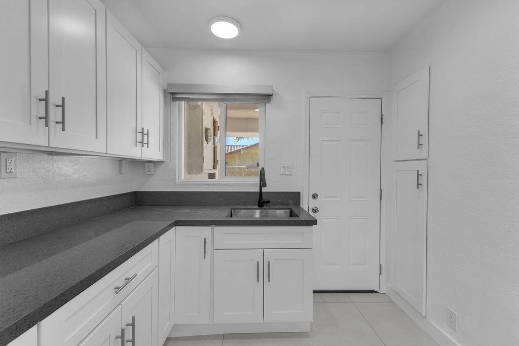 44635 San Carlos Avenue Palm Desert, CA 92260 - Photo 6 of 64 a kitchen with white cabinets and sink