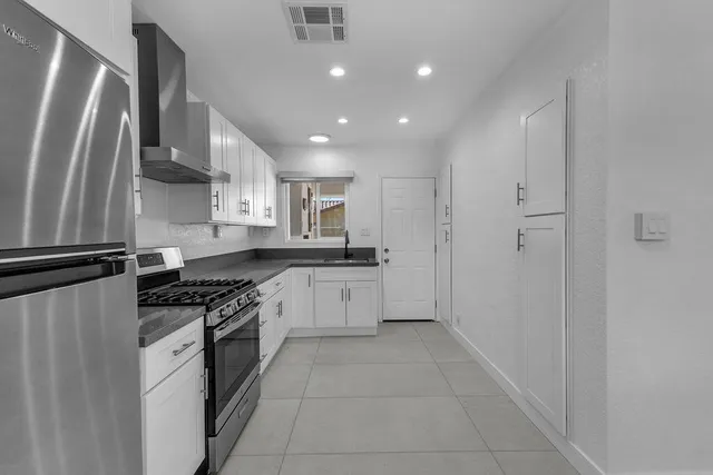 a kitchen with stainless steel appliances granite countertop a refrigerator and a sink