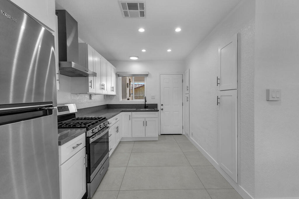 44635 San Carlos Avenue Palm Desert, CA 92260 - Photo 8 of 64 a kitchen with stainless steel appliances granite countertop a refrigerator and a sink