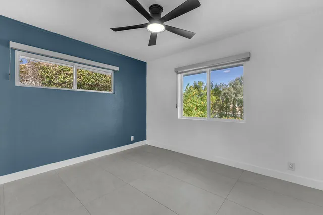 an empty room with window and ceiling fan