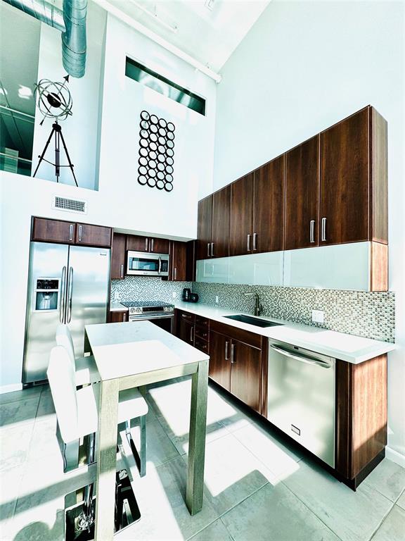 1490 Southeast 15th Street, Unit 202 Fort Lauderdale, FL 33316 - Photo 5 of 31 a kitchen with a stove a refrigerator and wooden cabinets