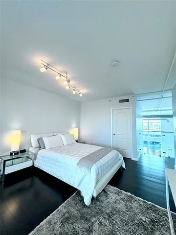 a bedroom with a bed and a view of living room