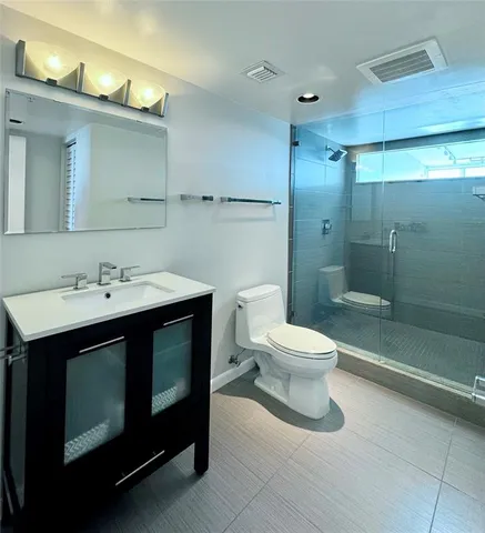 a bathroom with a sink toilet a mirror and shower