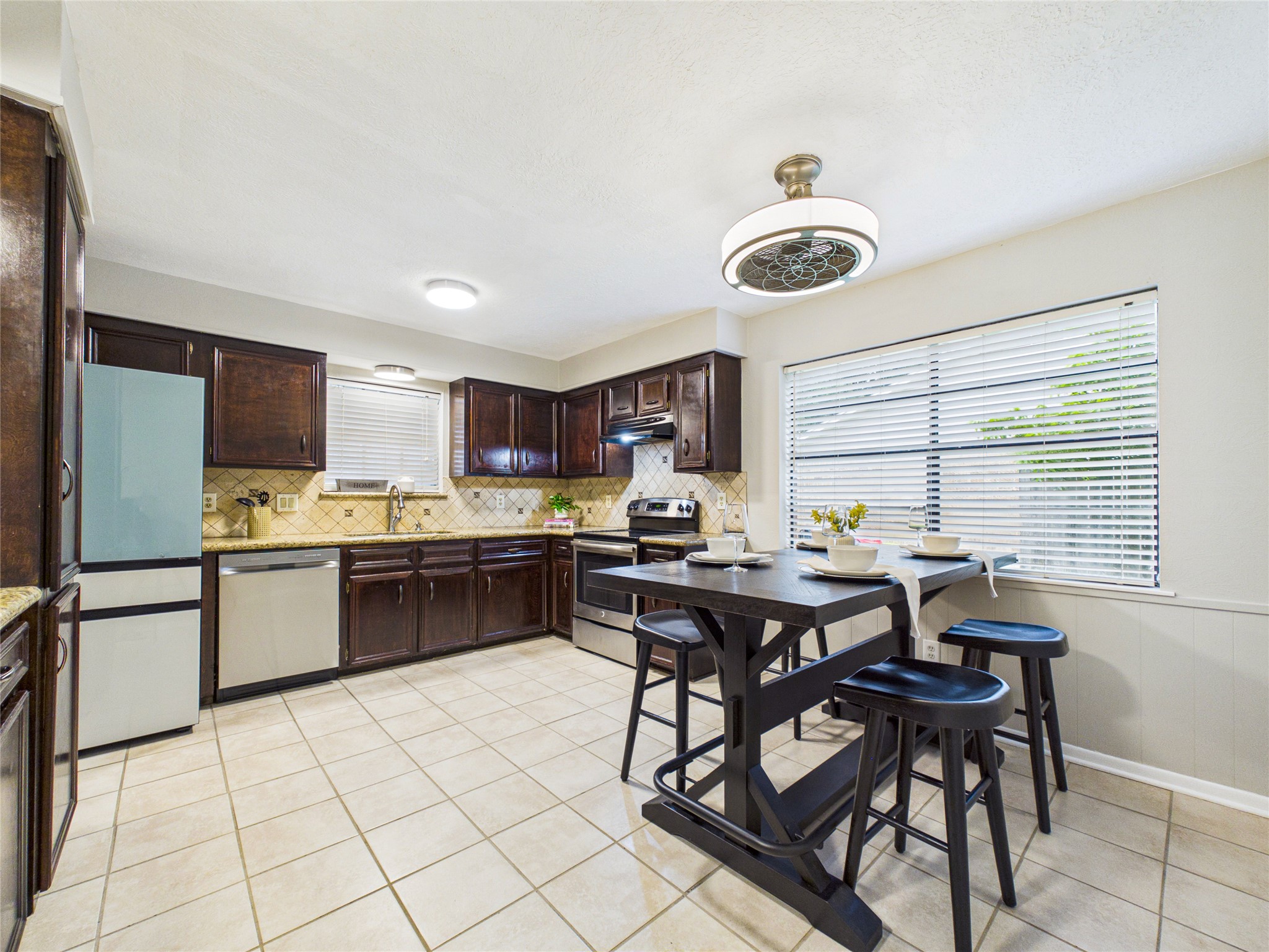 10306 Rustic Rock Road La Porte, TX 77571 - Photo 14 of 38 a kitchen with a table chairs microwave and cabinets