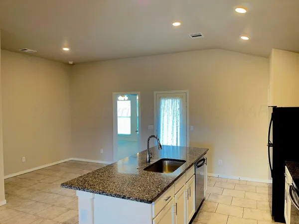 a kitchen with granite countertop a sink and a refrigerator