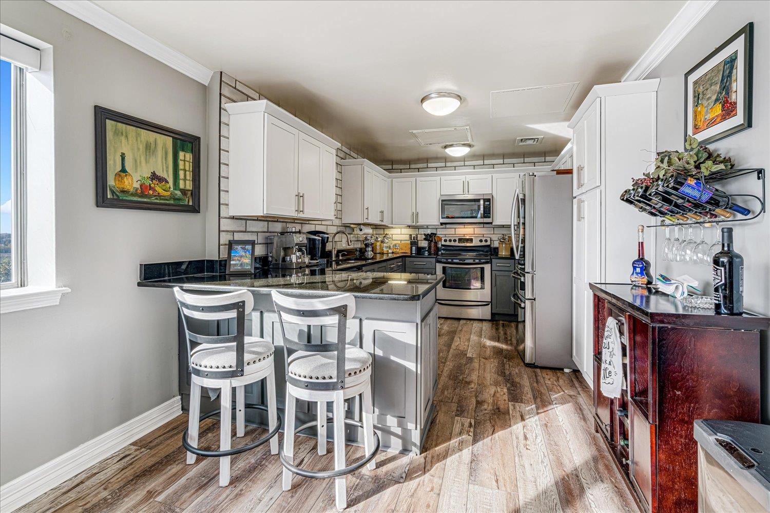 655 Riverside Drive, Unit 202 Memphis, TN 38103 - Photo 16 of 37 a kitchen with stainless steel appliances granite countertop a stove top oven a sink a dining table and chairs with wooden floor