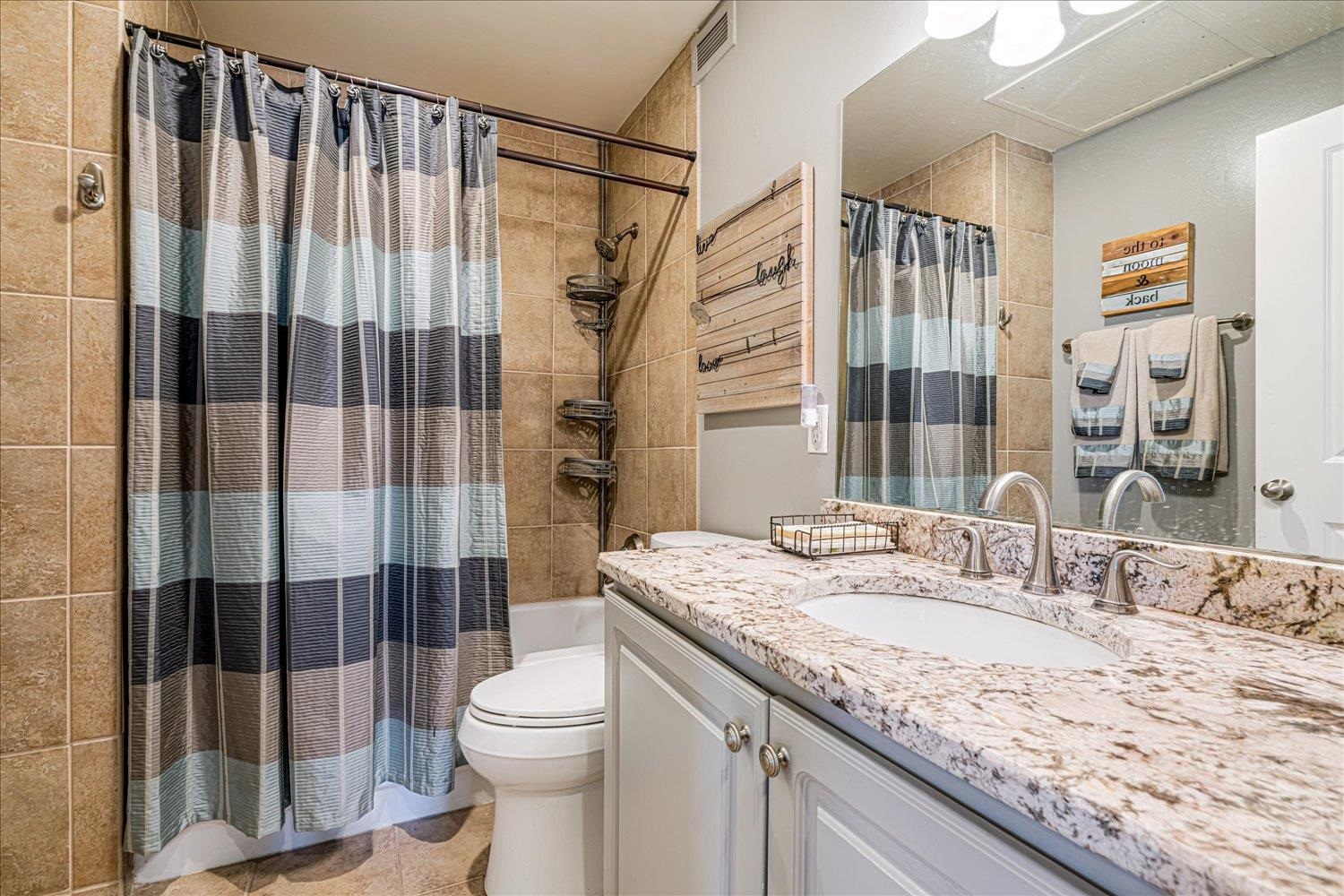 655 Riverside Drive, Unit 202 Memphis, TN 38103 - Photo 20 of 37 a bathroom with a granite countertop sink toilet and shower