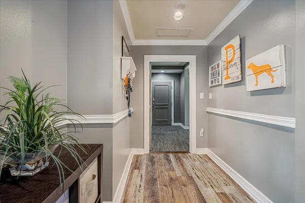 a view of a hallway with wooden floor and staircase