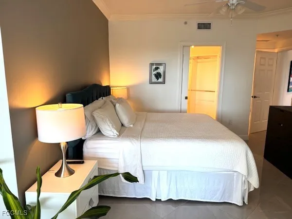 a bedroom with a bed a lamp and window