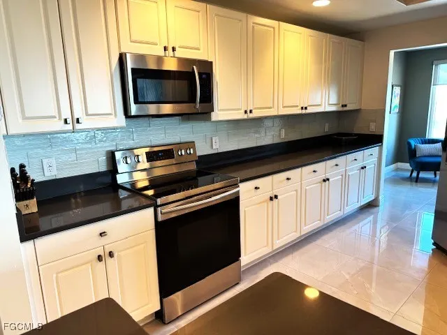 a kitchen with granite countertop a refrigerator and a sink
