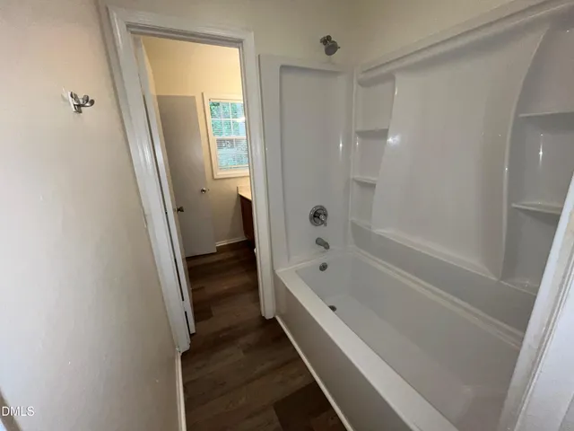 a bathroom with a tub shower and a sink