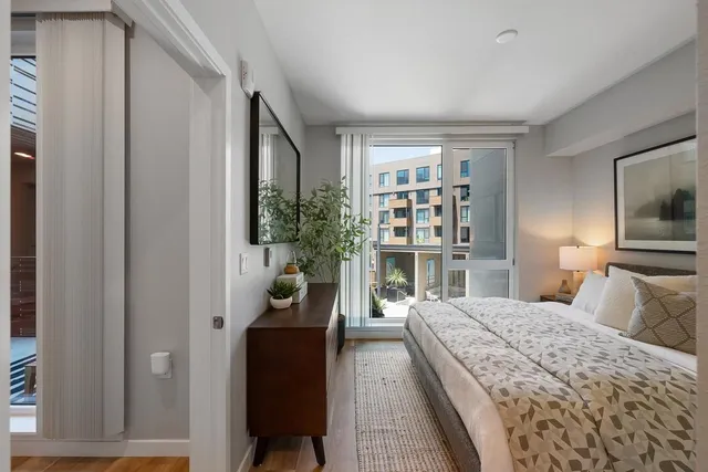 a bedroom with a large bed and a potted plant