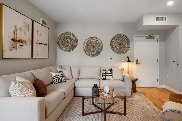 a living room with furniture and a wooden floor
