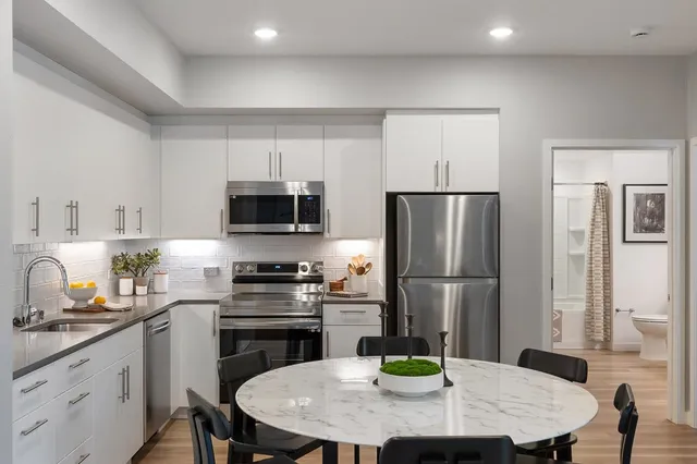 a kitchen with a stove a refrigerator and a dining table