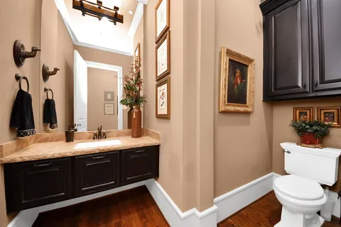 a bathroom with a granite countertop sink toilet and mirror