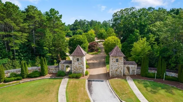 view of a house with a big yard potted plants and large tree