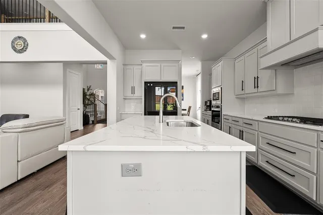 a kitchen with kitchen island sink stove and refrigerator