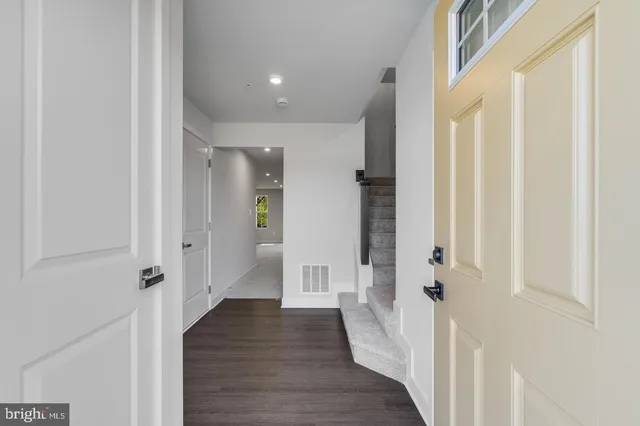 a view of a hallway with wooden floor and staircase