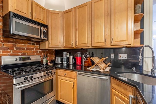 a kitchen with stainless steel appliances granite countertop a stove and a microwave