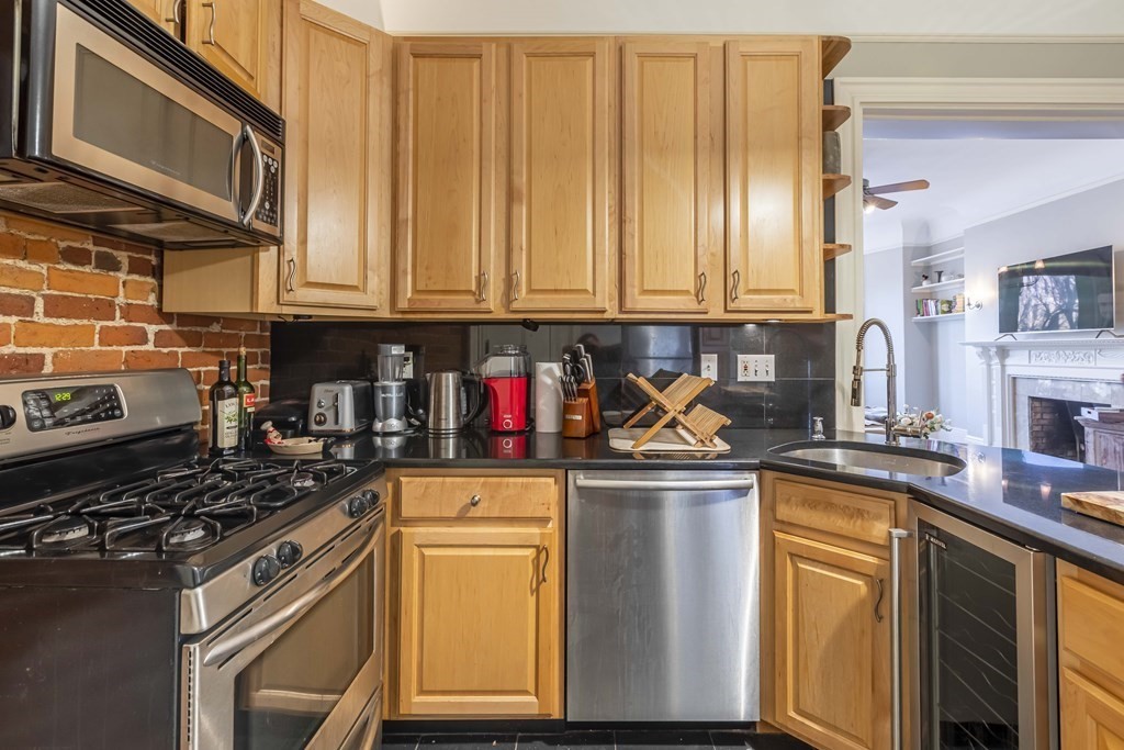 362 Commonwealth Avenue, Unit 2A Boston, MA 02115 - Photo 13 of 38 a kitchen with stainless steel appliances granite countertop a stove a sink dishwasher and cabinets with wooden floor