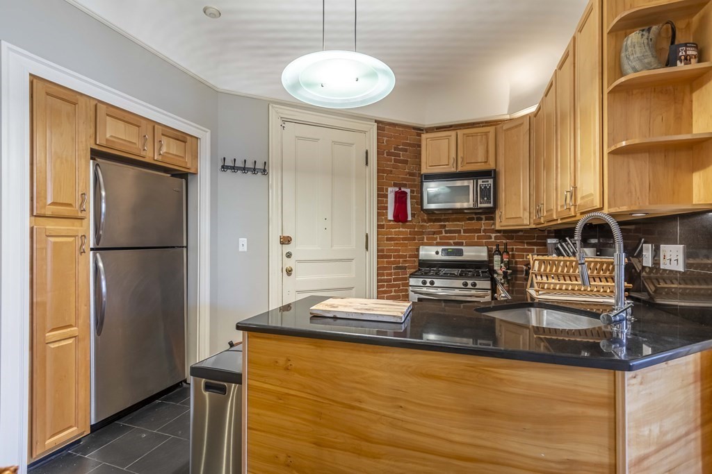 362 Commonwealth Avenue, Unit 2A Boston, MA 02115 - Photo 15 of 38 a kitchen with stainless steel appliances granite countertop a refrigerator a stove and a sink with granite countertops