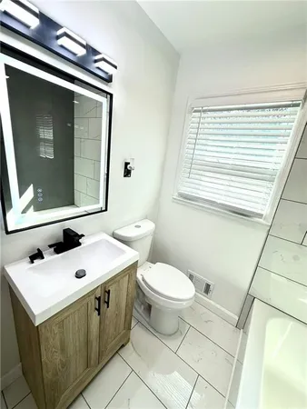 a bathroom with a sink toilet and mirror