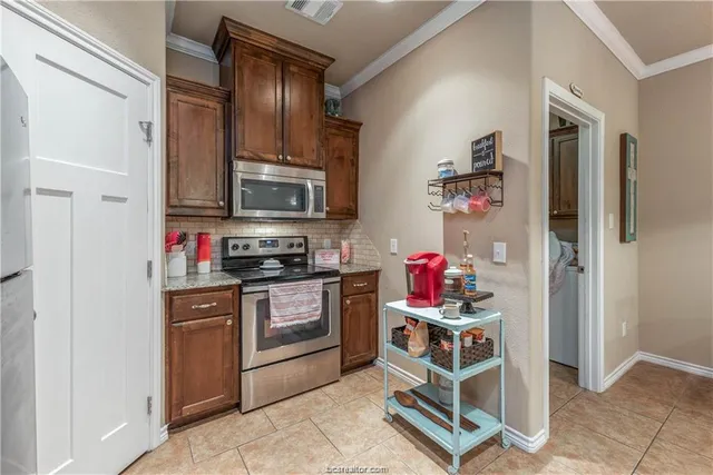 a kitchen with kitchen island granite countertop a sink cabinets and stainless steel appliances