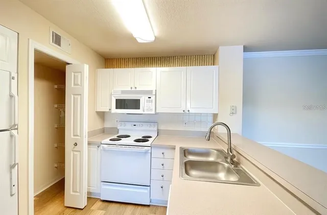 a kitchen with a sink cabinets and a window