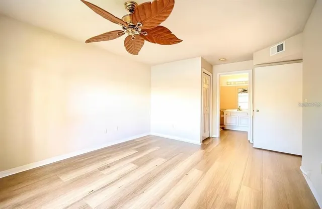 a view of a big room with wooden floor and a ceiling fan