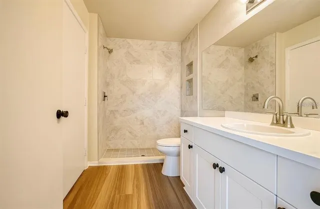 a bathroom with a sink a toilet and shower