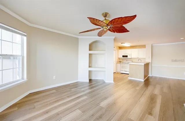 a view of a kitchen with wooden floor and a ceiling fan