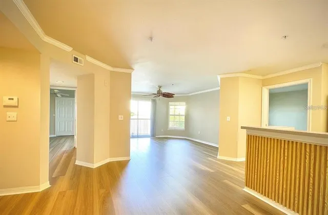 a view of a hallway with wooden floor and a bathroom