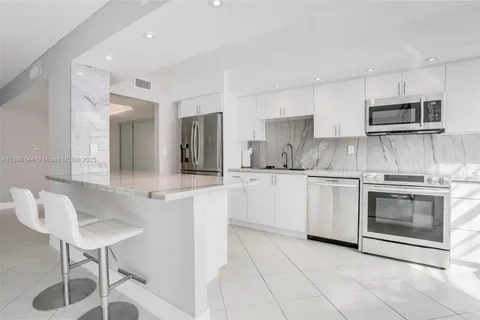 a kitchen with cabinets and chairs