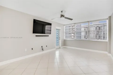 a view of an empty room with a window and a flat screen tv