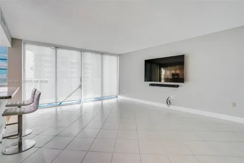 a view of an empty room with furniture and a window