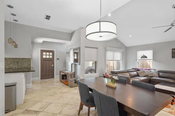 a living room with furniture a dining table and a chandelier
