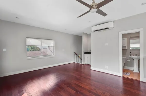 a view of an empty room with a window and wooden floor
