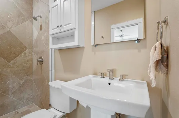a bathroom with a sink a toilet and shower