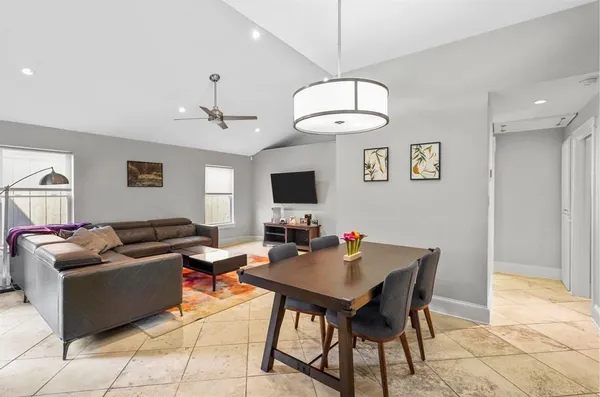 a living room with furniture a chandelier and a flat screen tv