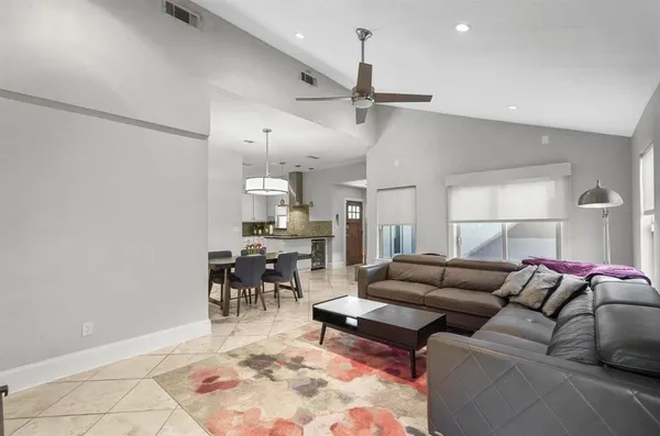 a living room with furniture and a dining table with kitchen view