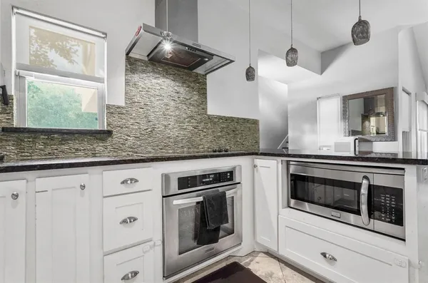 a kitchen with stainless steel appliances granite countertop cabinets and window