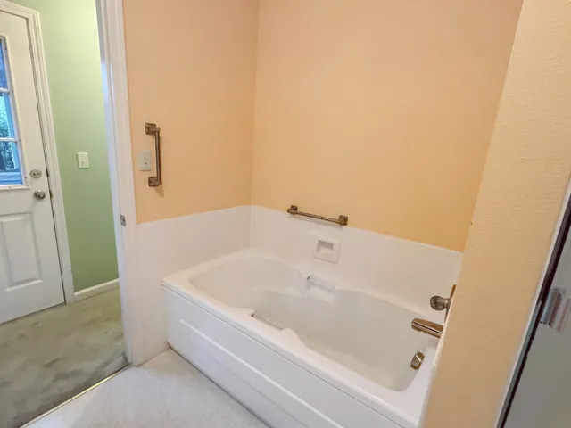 a white bath tub sitting next to a white sink and vanity