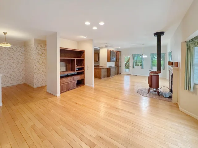a view of empty room with wooden floor and fireplace