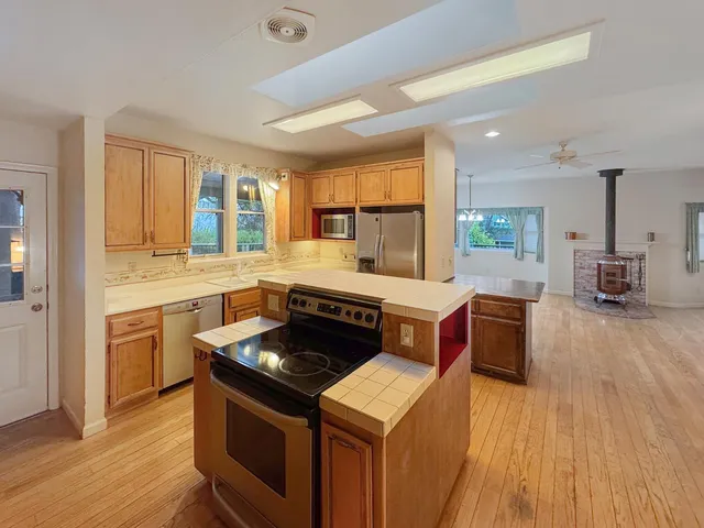 a kitchen with stainless steel appliances granite countertop wooden cabinets stove and sink