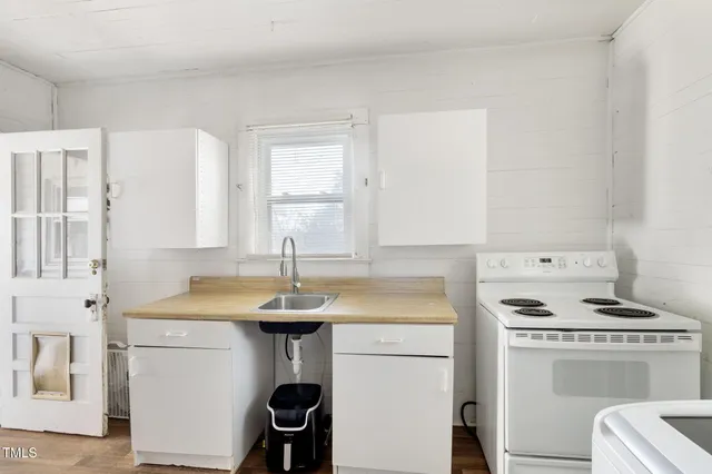 a kitchen with a sink stove and white cabinets
